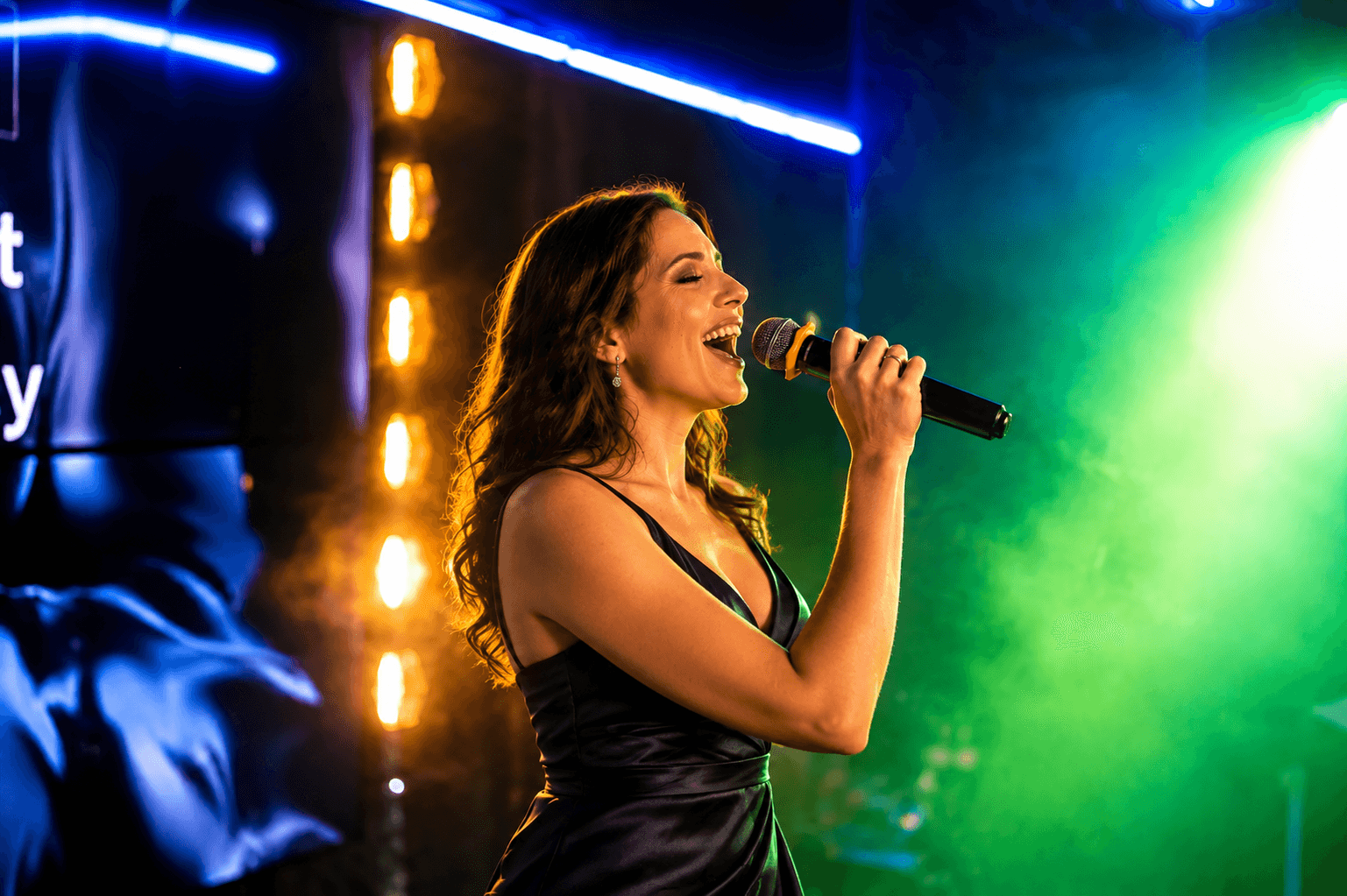 Singer in an evening dress under green and amber karaoke stage lights